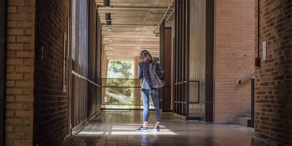 A university student walking down a long corridor